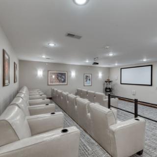 A modern home theater room with comfortable seating and a large screen.