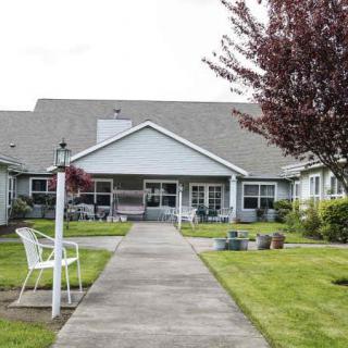 A residential building with a well-maintained lawn and pathway leading to the entrance.