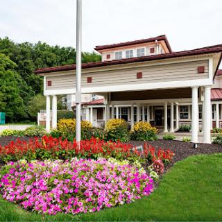 A beautiful building surrounded by vibrant flower beds and lush greenery.