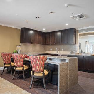 A modern kitchen interior featuring dark cabinetry and a sleek countertop with stylish bar stools.