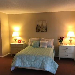 A cozy bedroom with a double bed, flanked by two illuminated nightstands.