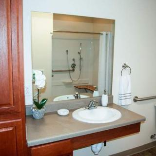 A bathroom vanity with a sink, mirror, and accessories.