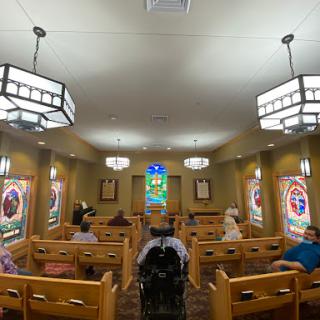 A spacious waiting room featuring wooden benches and decorative lighting.