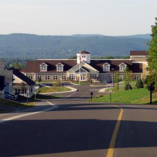 A scenic view of a residential building nestled among rolling hills.