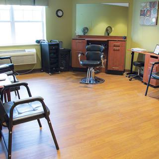 An empty barbershop interior with chairs and a stylist station.