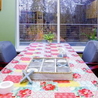 A cozy dining area with a floral tablecloth and a view of the garden.