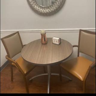 A cozy dining setup featuring a round wooden table and two chairs.