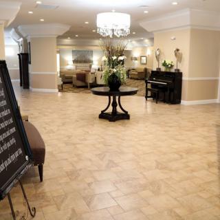 Spacious and elegantly decorated lobby with a central table and chandelier.