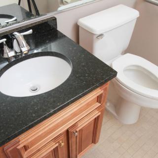A clean and modern bathroom with a sink, vanity, and toilet.