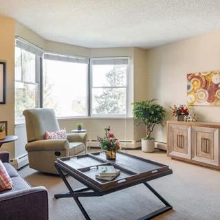 A cozy living room with large windows, comfortable seating, and tasteful decor.