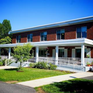 A modern building with a spacious entrance and landscaped surroundings.