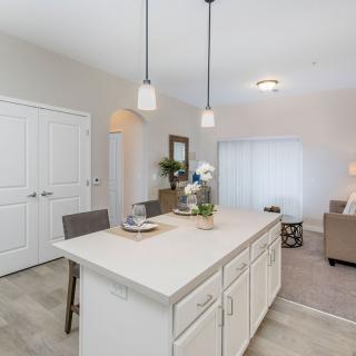 A modern, minimalist kitchen with a central island and pendant lighting.