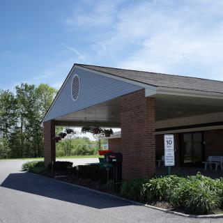 A view of a welcoming entrance to a brick building with well-maintained landscaping.