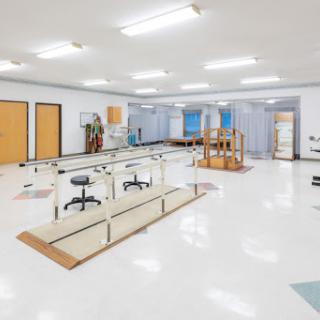 A spacious and well-lit physical therapy rehabilitation center, equipped with various exercise equipment and treatment areas.