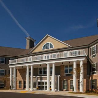 A large residential building with a prominent entrance featuring columns and a symmetrical facade.