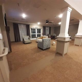 A spacious living room with comfortable seating and elegant pillars.