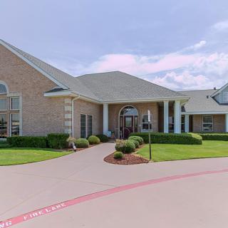 A suburban residential building with a well-maintained driveway and landscaping.