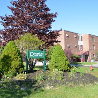 Entrance to a residential complex with well-maintained landscaping.
