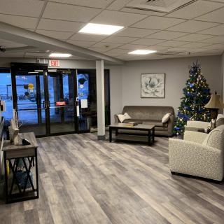 A cozy lobby with comfortable seating and a decorated Christmas tree.