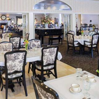 An elegant dining room with beautifully arranged tables and chairs, showcasing an inviting and sophisticated atmosphere.