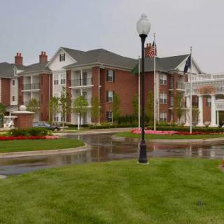 A suburban residential apartment complex with landscaped gardens and a street lamp.