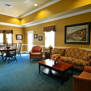 A cozy living room with a sofa, coffee table, and dining area.
