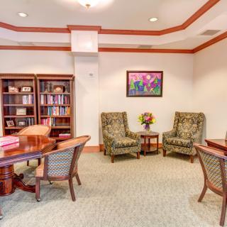 A cozy office space with bookshelves, a desk, and comfortable seating.