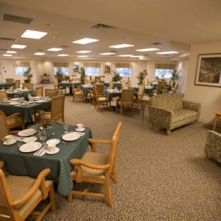 A spacious and well-lit dining area with neatly arranged tables and chairs.