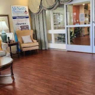A cozy lobby area with comfortable seating and hardwood floors leading to a glass entrance.