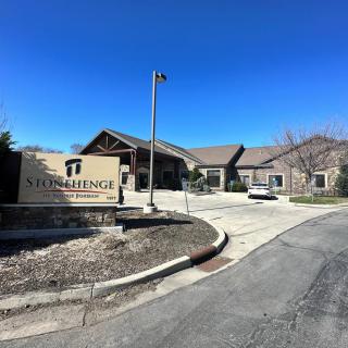 A building with a sign and driveway under a clear blue sky.