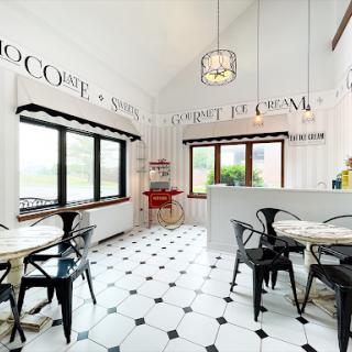 A stylish modern kitchen featuring a spacious dining area with elegant black and white tile flooring and ample natural light.