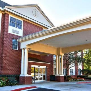 A building entrance with a covered driveway and brick exterior.