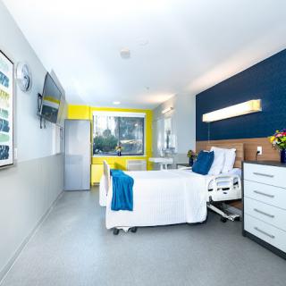 A modern and clean hospital room with bright lighting and a comfortable bed.