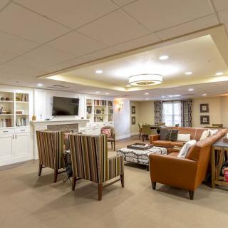 A cozy basement living space with comfortable seating, a television, and built-in shelving.
