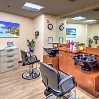 A cozy and well-organized hair salon interior with styling chairs, mirrors, and a hair wash station.