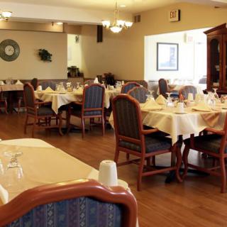 A spacious dining area in a restaurant with neatly arranged tables and chairs.