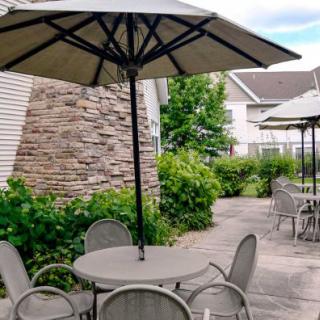 A cozy outdoor patio area with tables and chairs under large umbrellas.