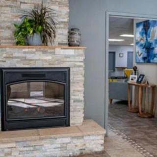 A modern living room featuring a stone fireplace and stylish decor.