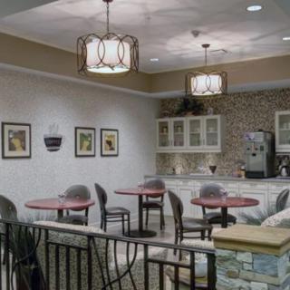 A cozy cafe interior with round tables, chairs, and decorative lighting.