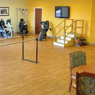 A fitness area featuring exercise equipment and rehabilitation facilities in a bright yellow environment.