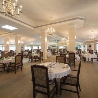 An elegant dining room with chandeliers and well-arranged tables, creating a refined atmosphere.