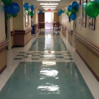A hospital corridor decorated with blue and green balloons.