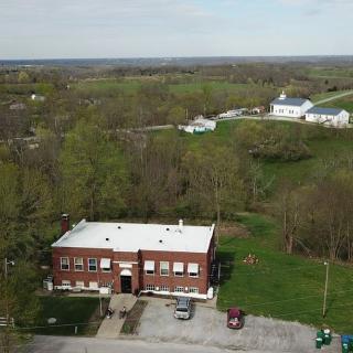 Aerial view of a brick building in a rural countryside setting.