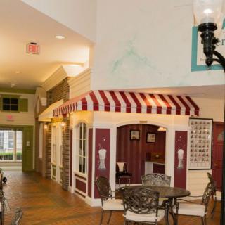 Cozy indoor cafe with tables and chairs under a striped awning.