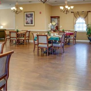 A spacious dining room with neatly arranged tables and chairs, elegant lighting, and tasteful decor.
