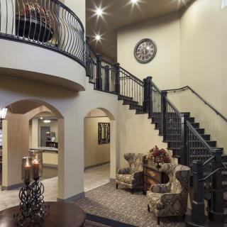 A modern living area featuring a grand staircase and elegant furnishings.