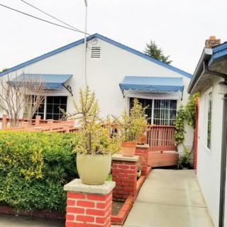 A charming house with brick pillars and potted plants lining the walkway.