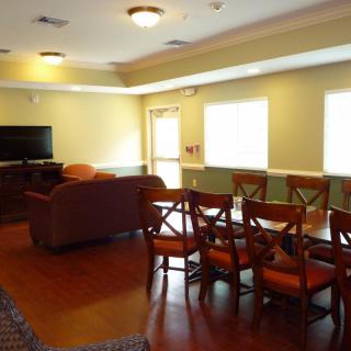 A cozy living and dining area with a sofa, chairs, and a television.