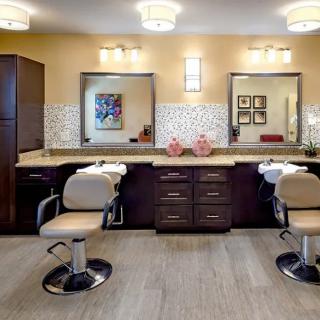 A modern salon interior with stylish chairs and large mirrors.