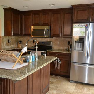 A modern kitchen with wooden cabinets and stainless steel appliances.